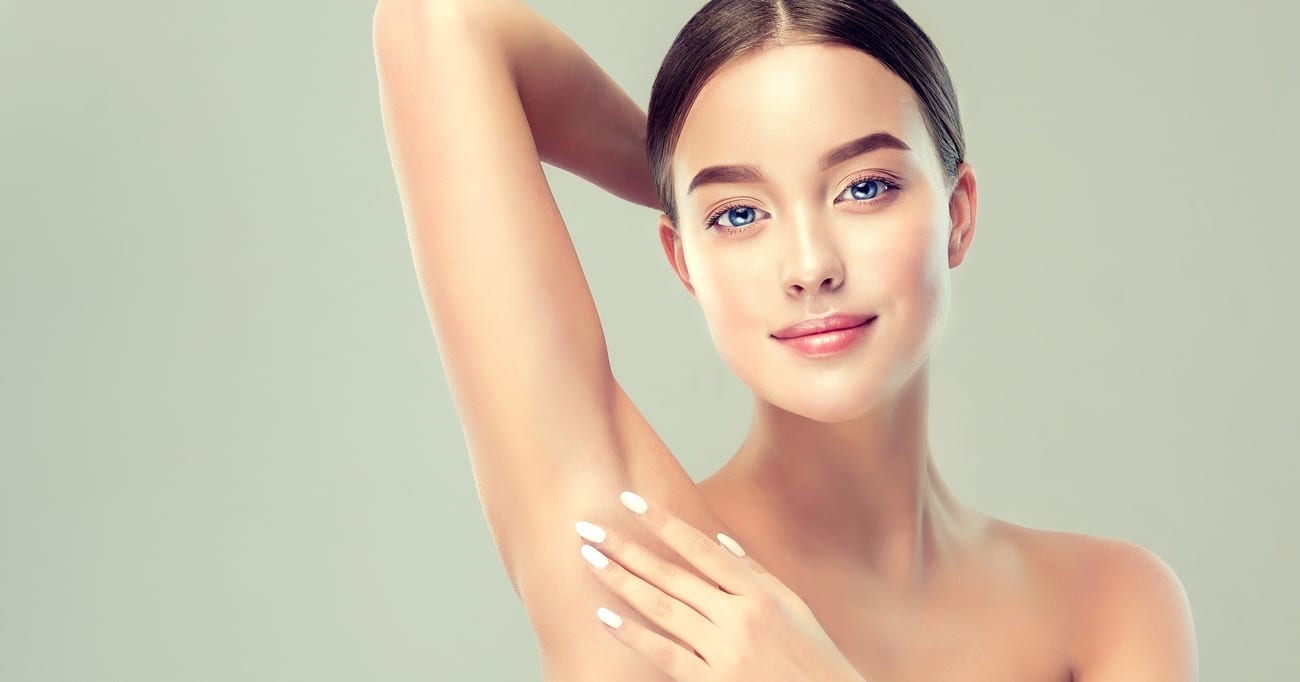 Gorgeous, young, blue-eyed woman  is touching the clean, soft skin of own armpit. Pure woman's beauty. Facial and skin treatment, cosmetology, beauty technologies and armpit epilation.
